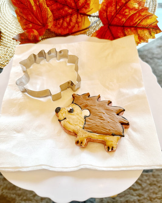 hedgehog cookie cutter for fall autumn on plate surrounded by leaves foliage